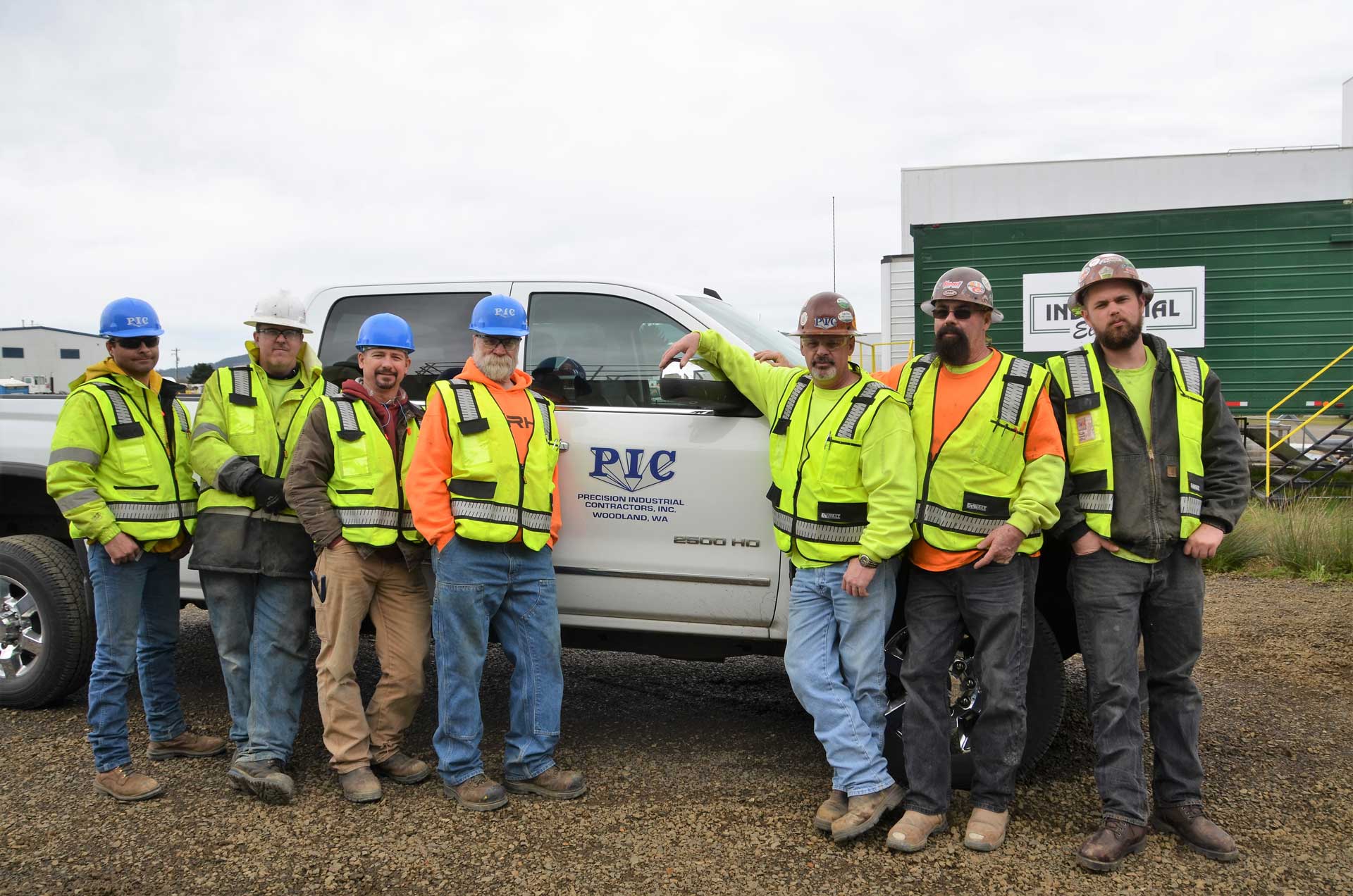 Picture of seven industrial workers standing in front of a pickup truck with the PIC logo